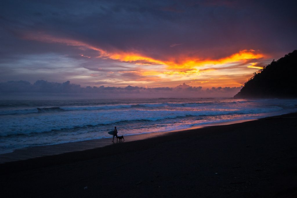 Surfer at the end of the day, with sunset, Jaco Beach, Costa Rica