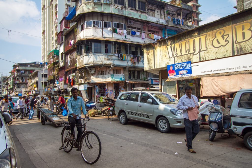 cyclist, street scene and apartment block in Mumbai India