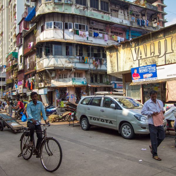 cyclist, street scene and apartment block in Mumbai India