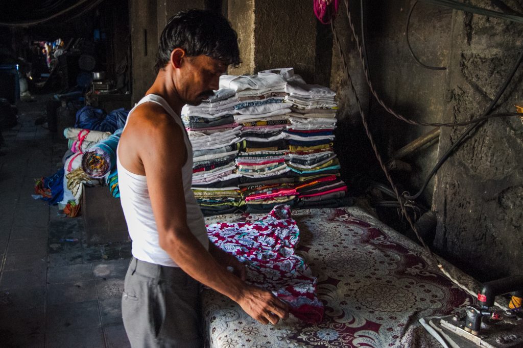 Man ironing in Dhobi Ghat laundry