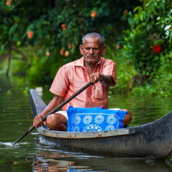 A man paddles a riverboat on Kerala's backwaters, near Allepey, India