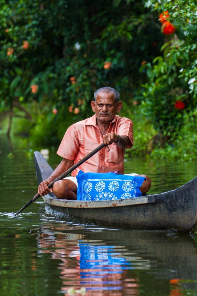 A man paddles a riverboat on Kerala's backwaters, near Allepey, India