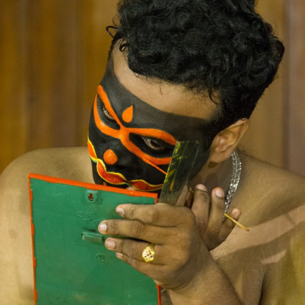 An actor applying makeup before a Kathakali theatre show in Fort Kochi, Kerala, India